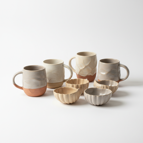 Artisan aesthetic ceramic mugs and shell cups in earthy neutral tones on white background