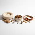 Collection of pet supplies including food bowl, leash, collar, grooming brush and pet bed on white background